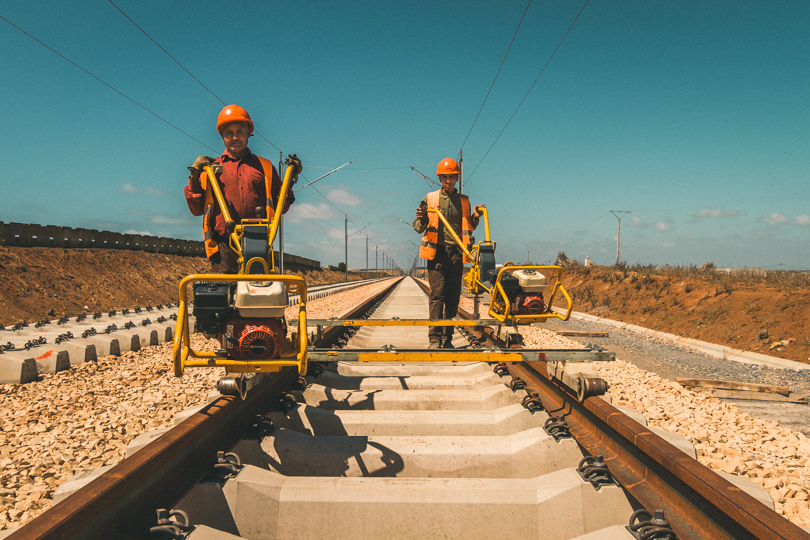 Railroad workers fixing rails on sleepers