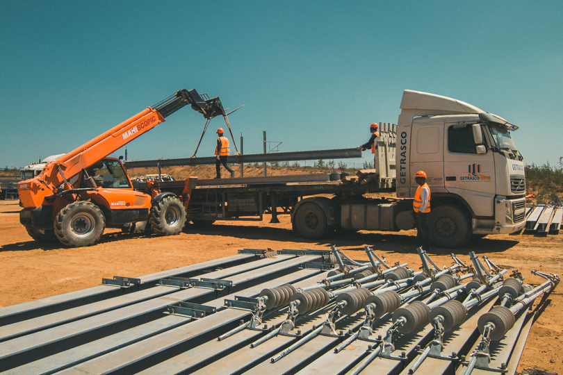 Catenary poles being loaded on truck