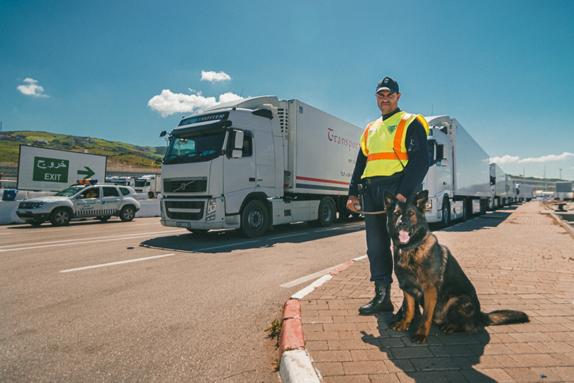 Portrait Photograph of Security canine unit in front of trucks waiting to embark on ferry